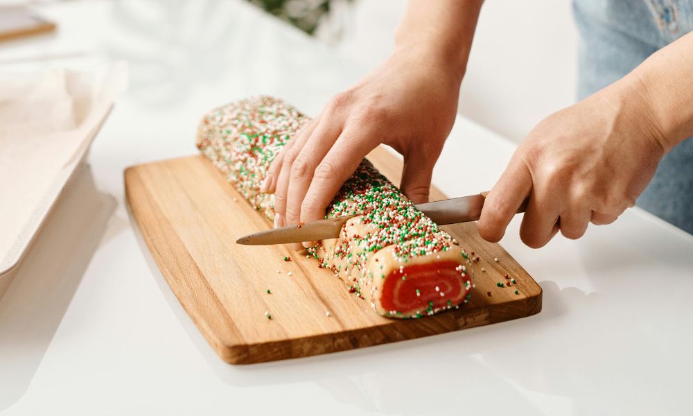 slicing a cake on a chopping board