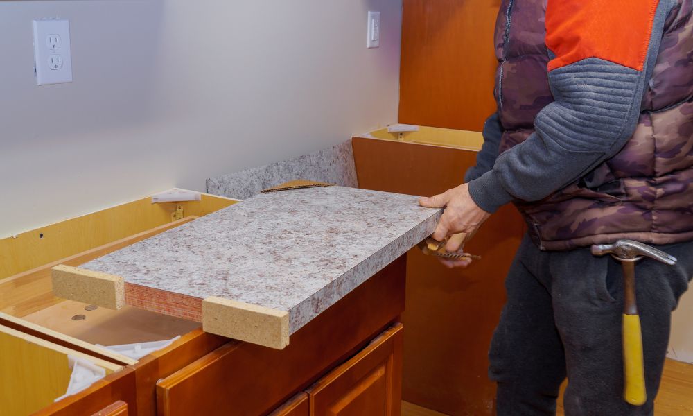 installers installing a stone kitchen countertop in customer's house