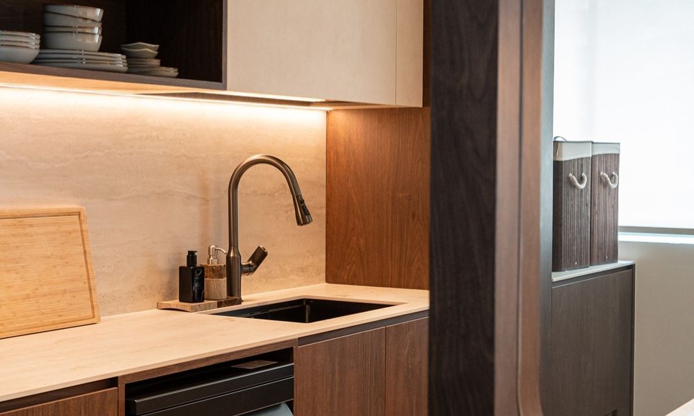 kitchen warm wood tones and Aurastone's MYSA Crème Travertino stone create a rich, grounded aesthetic