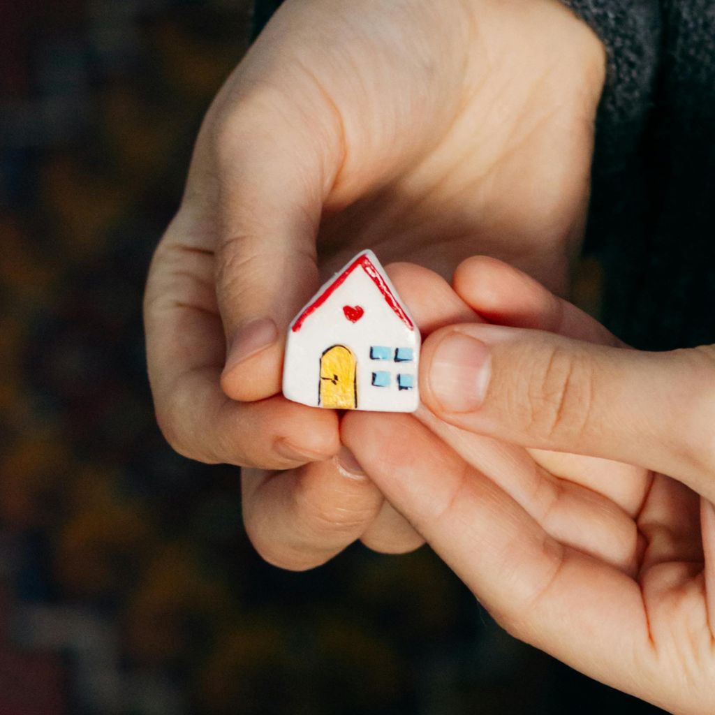 hands holding a replica house as symbol of a dream home